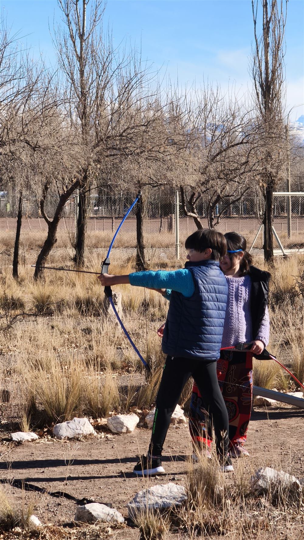 Niños apuntando con sus arcos durante la experiencia de tiro con arco